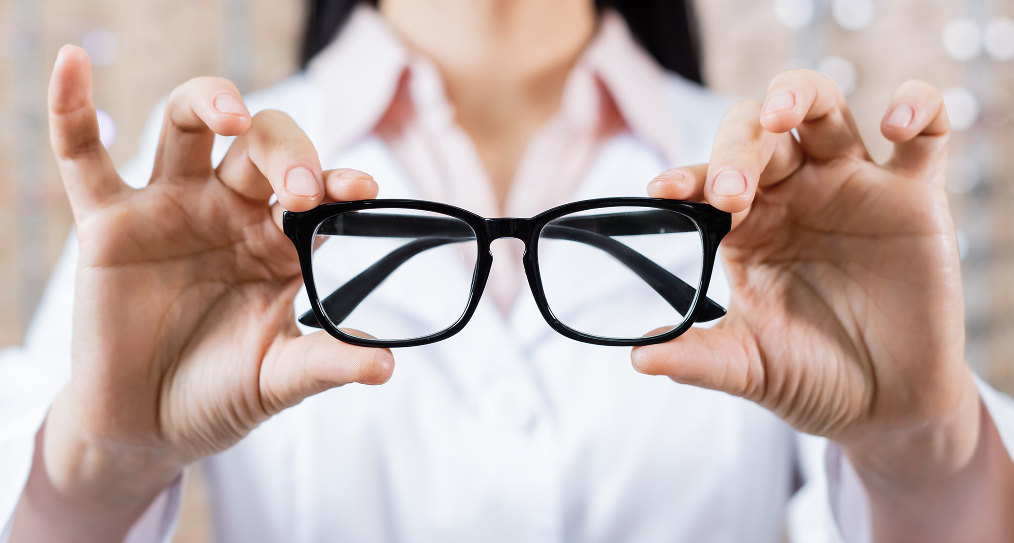 mano sujetando una montura negra de gafas