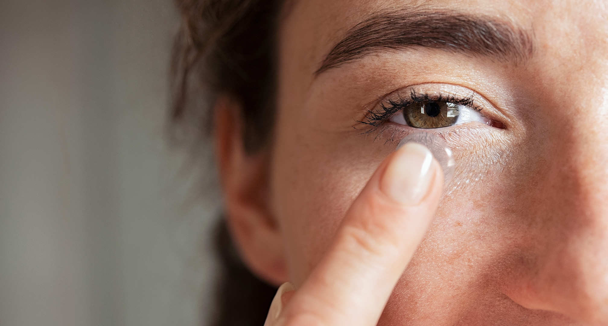 primer plano de una persona sosteniendo una lentilla delante del ojo 